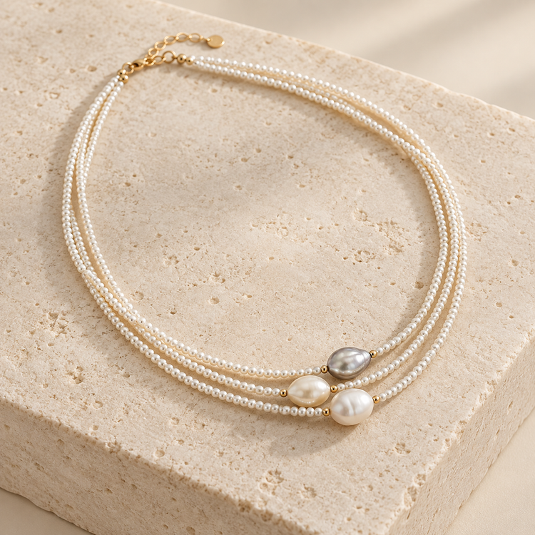 Rivière three-strand pearl necklace on ivory stone