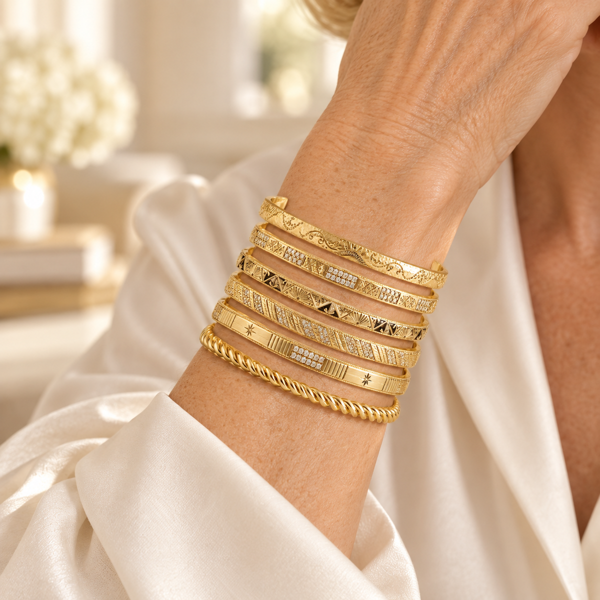 Atelier engraved bangle stack worn by a mature woman